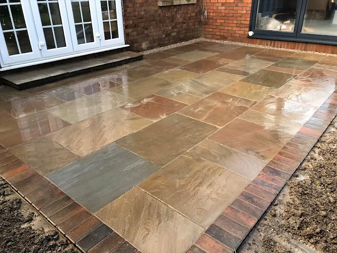 Indian stone patio with brick edging, completed by JB Groundwork Solutions in York